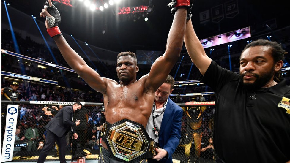 Francis Ngannou having the UFC  heavywieght champion of the world belt put on world 